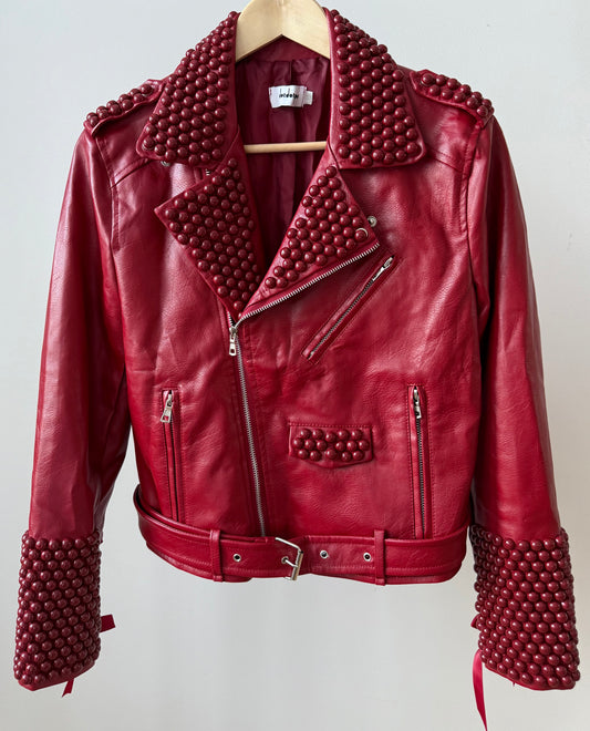Red faux PU leather moto biker jacket showcasing dome studs and satin lace-up sleeves.