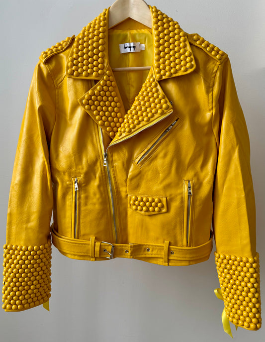 Yellow faux PU leather moto biker jacket showcasing dome studs and satin lace-up sleeves.