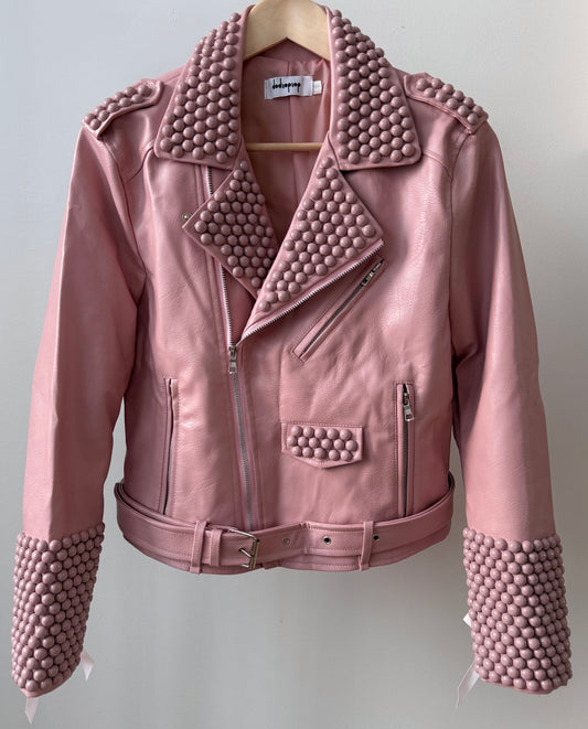 Pink faux PU leather moto biker jacket showcasing dome studs and satin lace-up sleeves.